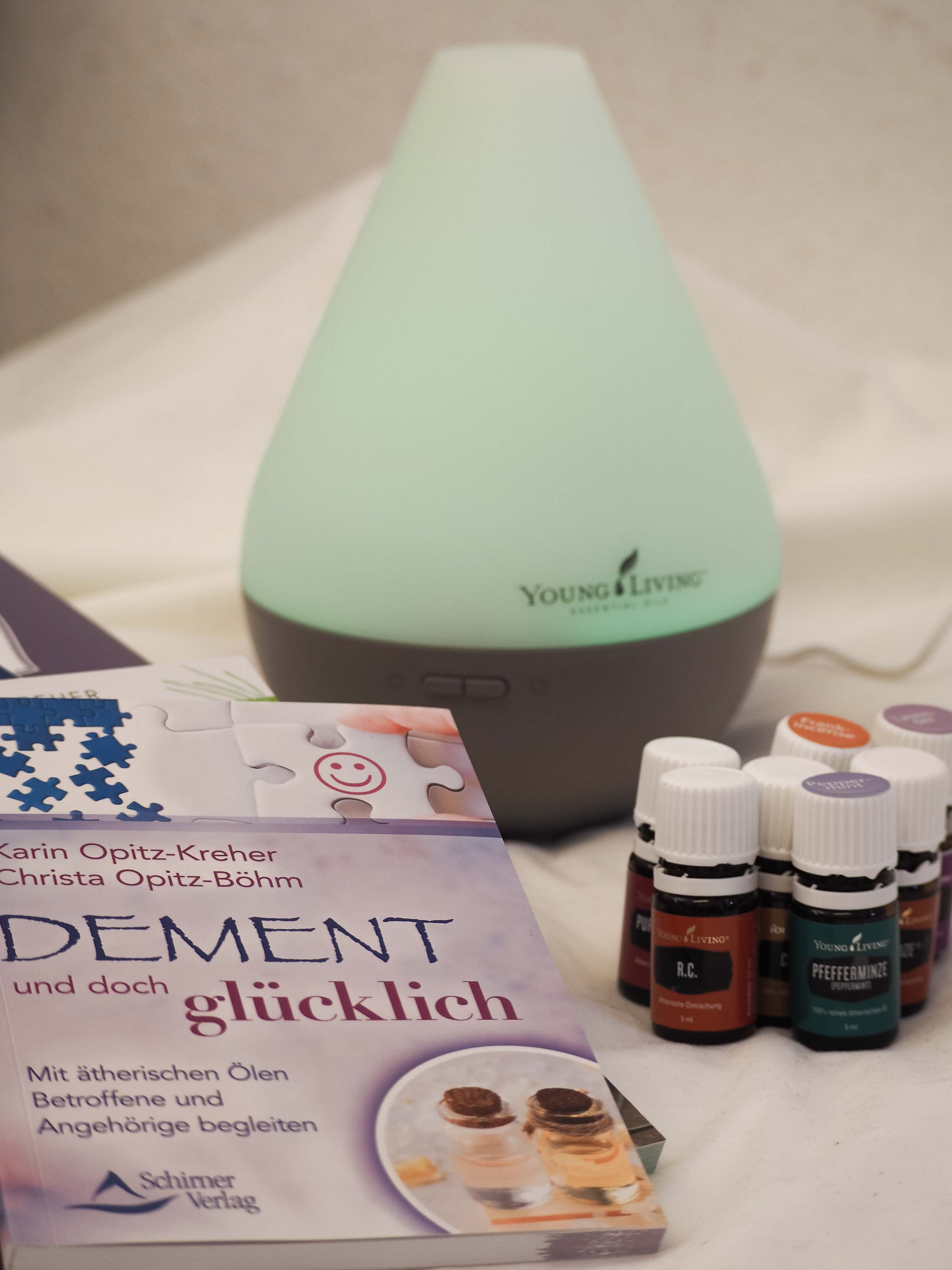 Öle mit der Duftlampe und dem Buch Dement und doch glücklich